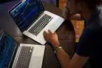 man sitting in front of the MacBook Pro