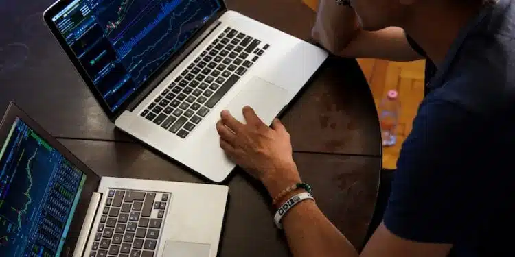 man sitting in front of the MacBook Pro